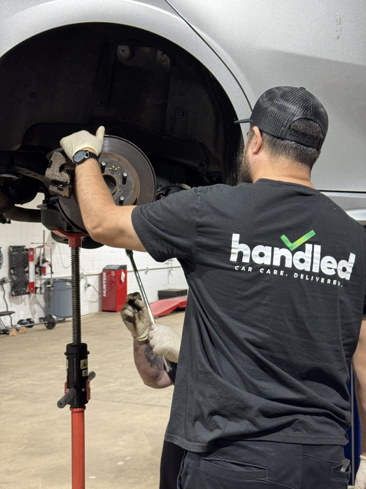 A Handled automotive technician at work on a car's brakes